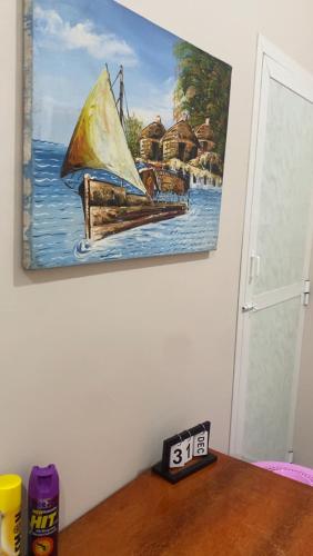 a painting of a sail boat on the wall at Mnazinisky B&B in Zanzibar City