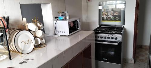 eine Küche mit Herd und Mikrowelle in der Unterkunft Lovely Apartments at Rehema 2B in Kisumu