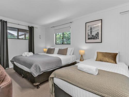 2 bedden in een witte kamer met ramen bij Lennox Coastal Retreat - resort-style home w. pool in Lennox Head