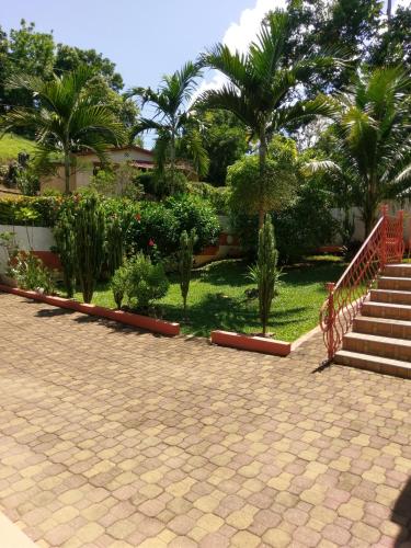 a courtyard with stairs and palm trees and a staircase at Polish Princess Guest House in Port Antonio