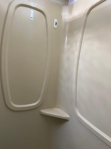 an airplane bathroom with two windows and a shelf at Comfortable and cozy RV in Lehigh Acres