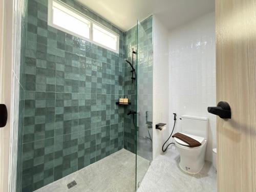 a bathroom with a toilet and a glass shower at บ้านระเบียงทะเล หัวหิน in Hua Hin