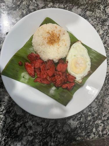 a plate of food with rice and eggs on a banana leaf at Tipid Camp Baguio A4,A5,A6 in Baguio