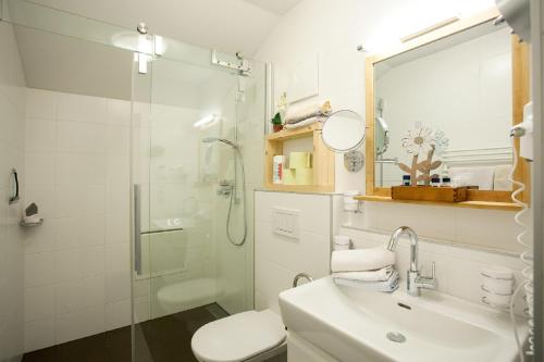 a bathroom with a toilet sink and a shower at Gästehaus Waldrand Garni in Wiesing