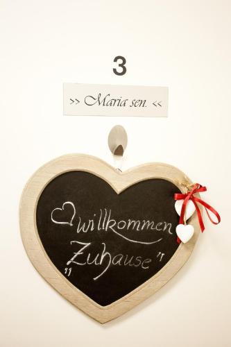 a heart shaped blackboard with the words uilumnumn appliance at Gästehaus Waldrand Garni in Wiesing