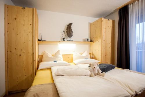 a bedroom with two beds with a teddy bear sitting on them at Gästehaus Waldrand Garni in Wiesing