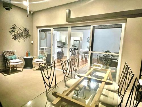 a living room with chairs and a glass table at Relaxed Cosy Beach Room Close to Airport in Sydney