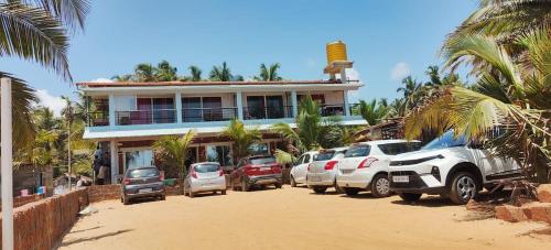 un edificio con auto parcheggiate di fronte di Gokarna Govekar Sea Facing Rooms a Gokarn