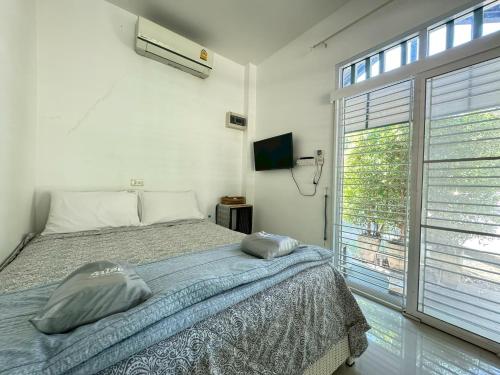 een slaapkamer met een bed en een groot raam bij ComeHome Lamphun in Lamphun