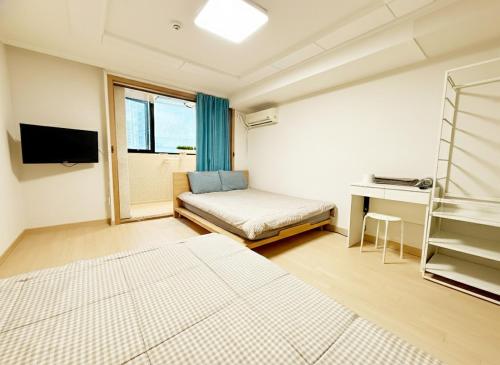 een slaapkamer met een bed, een bureau en een raam bij Namsan Forest in Myeongdong in Seoul