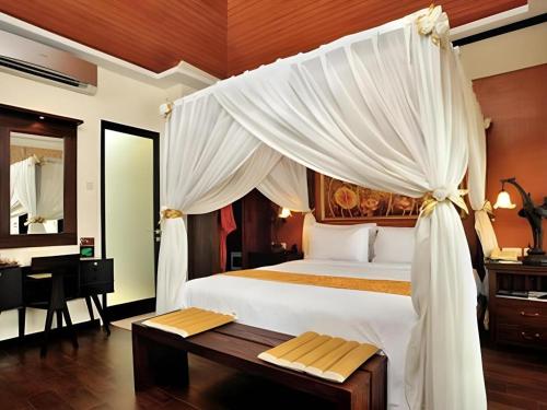 una camera da letto con un letto grande con tende bianche di Savali Hotel a Kampungdurian
