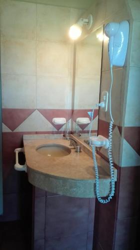 a bathroom with a sink with a hair dryer at Establecimiento Rural El Chañar in San Rafael