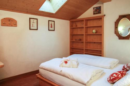 a bedroom with two beds and a skylight at Residence Salvan in Corvara in Badia
