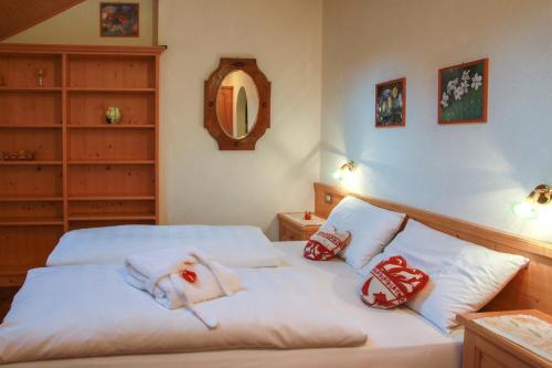 a bedroom with two beds with pillows and a mirror at Residence Salvan in Corvara in Badia