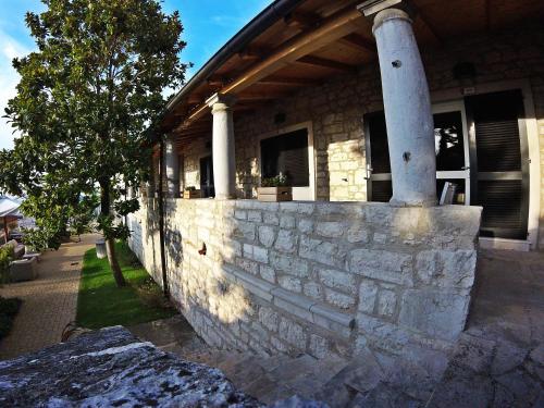 a house with a stone wall and a pillar at Hotel Vista in Vrsar
