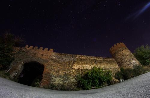 una vieja pared de ladrillo con un arco por la noche en Galavnis Kari Hotel, en Signagi