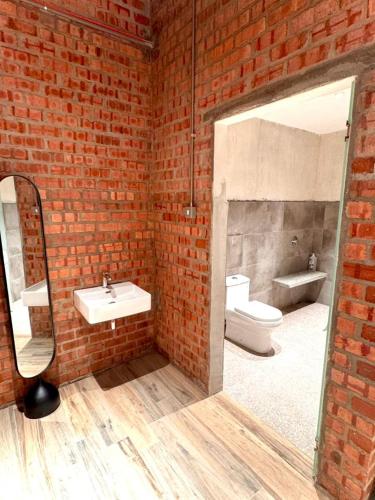a brick bathroom with a sink and a toilet at Brick Box Family Hotel Ipoh in Ipoh