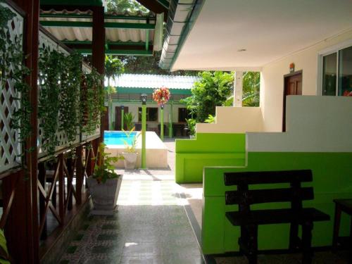 a house with green walls and a patio with a pool at Nayai Resort in Chalong 