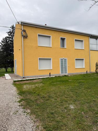 a yellow building with windows on the side of it at Elena's apartment - casa gialla in Quartesana