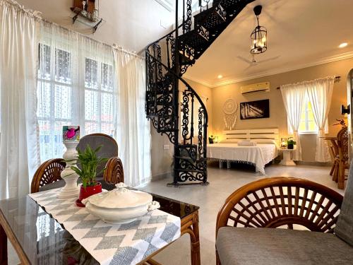 un soggiorno con tavolo, sedie e un letto di STARBURST By The Beach Goa a Benaulim