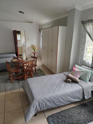 a bedroom with a bed and a table and chairs at Heights in Cedara