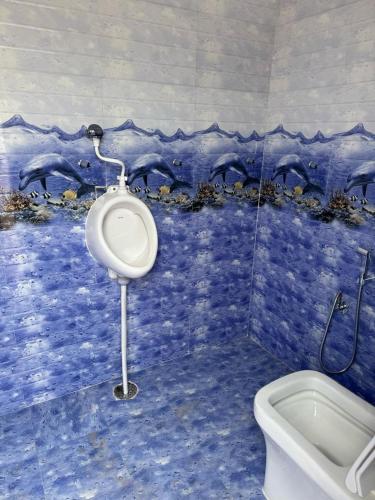 a bathroom with a toilet and dolphins on the wall at Hari Vatika in Varanasi