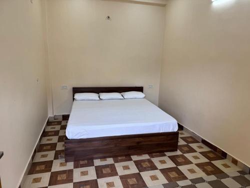 a small bedroom with a bed with two pillows at Hari Vatika in Varanasi