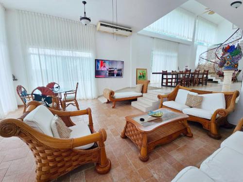 a living room with wicker chairs and a table at Hillside Villa with ocean views in Puerto Vallarta