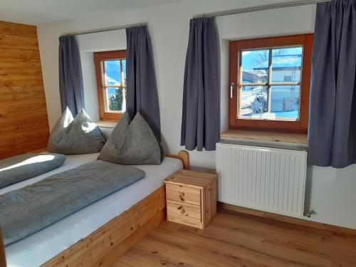 a bedroom with two beds and a window at Ferienwohnung Schwalbennest in Hopfgarten im Brixental
