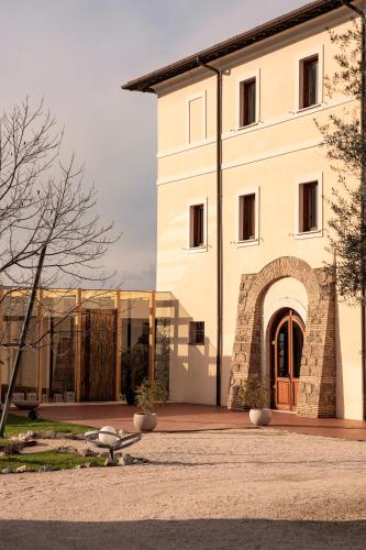 a large white building with an archway in front of it at Cincinnato Wine Resort in Cori