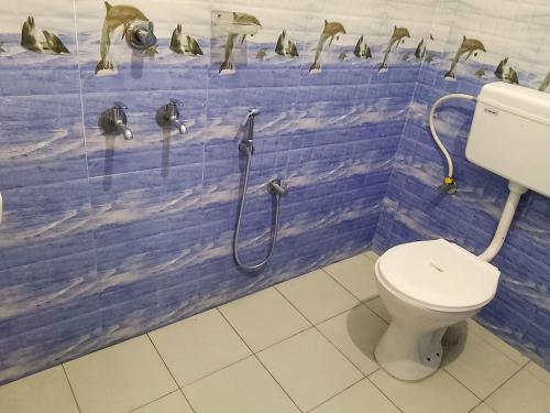 a bathroom with a toilet and penguins on the wall at Somatheertham Resort in Kovalam