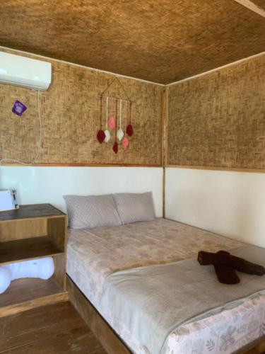 a small bedroom with a bed and a table at Boneputeh Homestay in Taliwang
