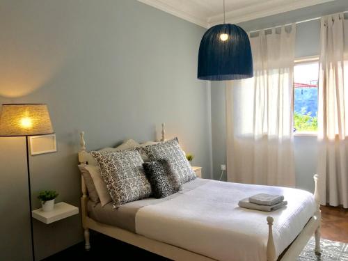 a bedroom with a bed and a lamp and a window at Apartamento Porto Baixa in Porto