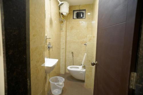 un bagno con un water e un lavandino di The Residency Inn Visawa Kolhapur a Kolhapur