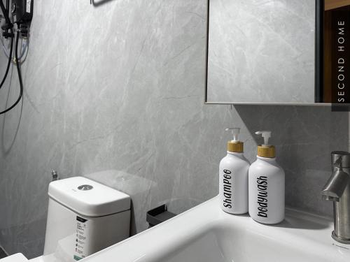 two bottles ofodorizers sit on a bathroom sink at Second Home - Kota Kemuning in Shah Alam