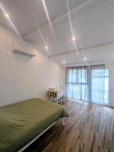 a bedroom with a bed and a table in it at Studio RDC proche aéroport in Saint-Laurent-de-Mure