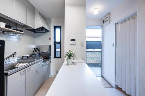 a kitchen with white cabinets and a white counter top at 桜木 Stay Ise 伊勢神宮まで車で6分 駐車場あり in Ise