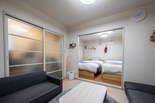 a living room with a couch and a bedroom at 桜木 Stay Ise 伊勢神宮まで車で6分 駐車場あり in Ise