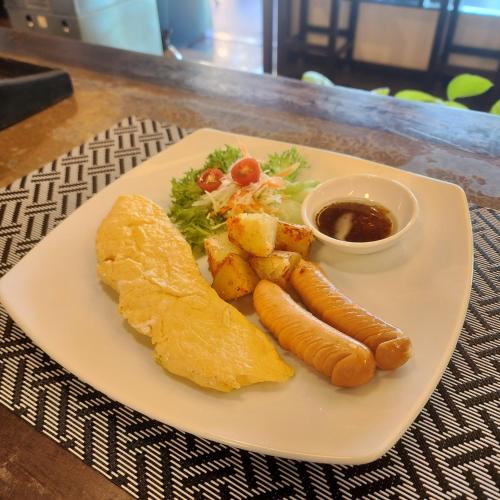 a plate of food with carrots and a side of sauce at Lanta Mermaid Boutique House in Ko Lanta