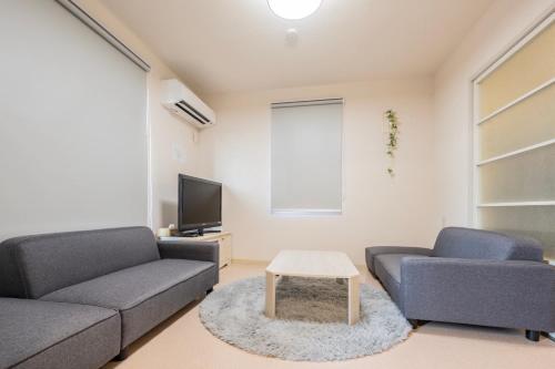a living room with two couches and a table at 桜木 Stay Ise 伊勢神宮まで車で6分 駐車場あり in Ise