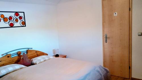 a bedroom with a bed with a wooden headboard at Ferienwohnung Gräßl - Almzeit in Preitenegg