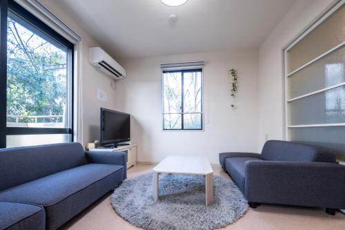 a living room with two blue couches and a tv at 桜木 Stay Ise 伊勢神宮まで車で6分 駐車場あり in Ise