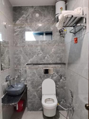 a bathroom with a white toilet and a sink at Hotel Sobhagyam in Kekri