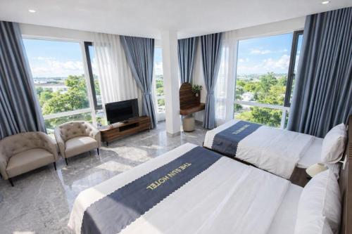 a hotel room with two beds and a television at The Sun Hotel - Ninh Bình in Kỳ Vĩ