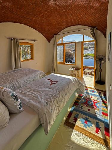 a bedroom with a bed and a large window at ASSINGAR Island in Aswan