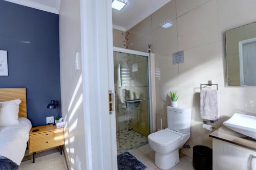 a bathroom with a toilet and a shower and a sink at Albatross @ Kingswood in George