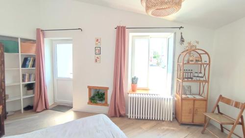 a bedroom with a bed and a window and a chair at La Ferme du Papillon in Pougne-Hérisson