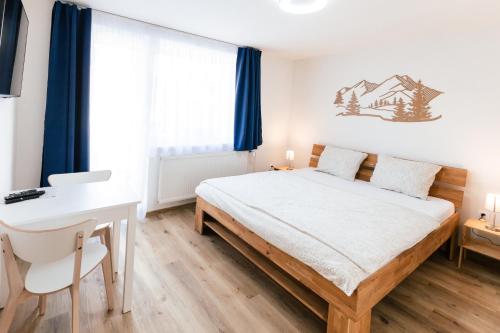 a bedroom with a bed and a desk and a window at INLE Homestay in Nová Lesná