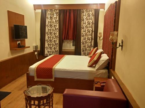 a hotel room with a bed and a window at Hotel Savoy - Since 1951 in Jaipur