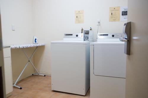 a kitchen with two refrigerators and a table and a refrigerator at Distinction New Plymouth Hotel in New Plymouth